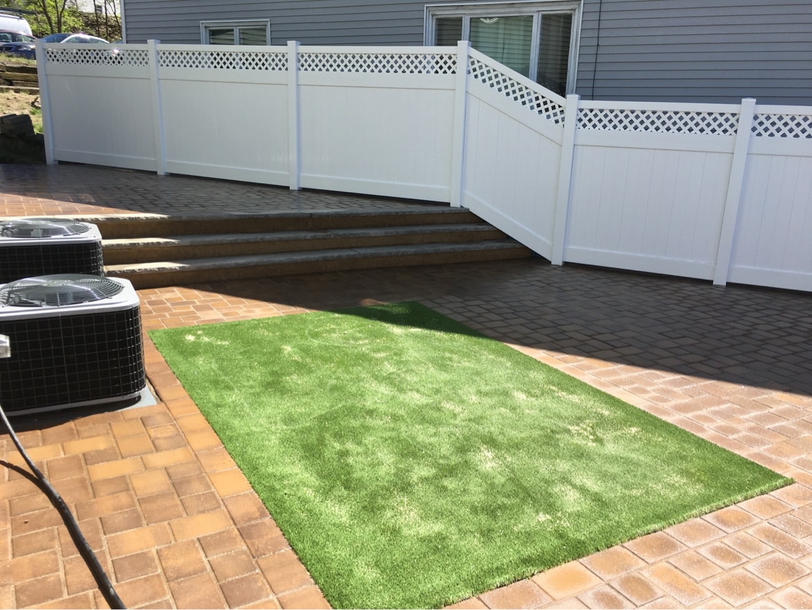 White vinyl privacy fence with lattice top over paver patio